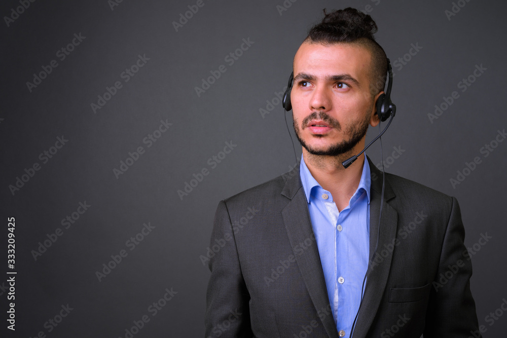 Face of handsome bearded Turkish businessman as call center representative thinking Face of handsome bearded Turkish businessman as call center representative thinking
