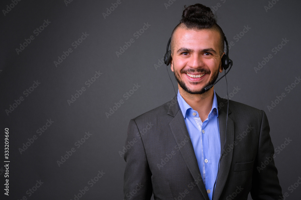 Face of happy bearded Turkish businessman as call center representative smiling Face of happy bearded Turkish businessman as call center representative smiling