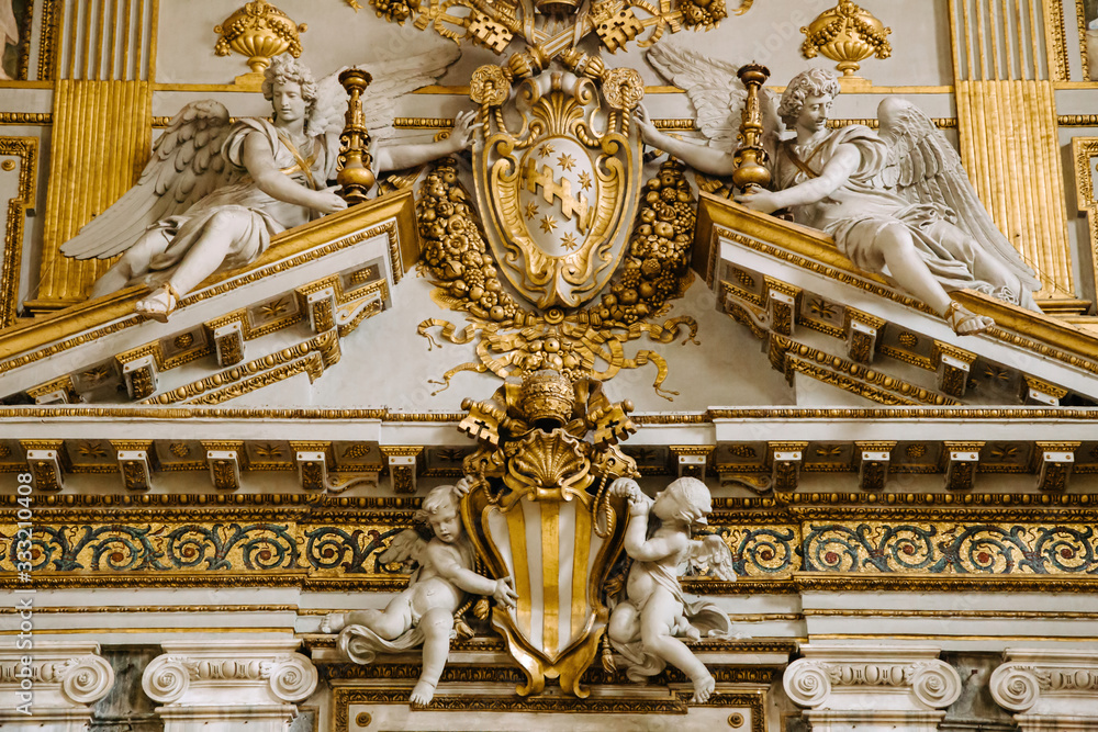 Fototapeta premium Rich ornate interior detail of church, golden decoration of the walls.