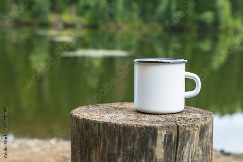 Valokuva White enamel mug mockup with tree stump