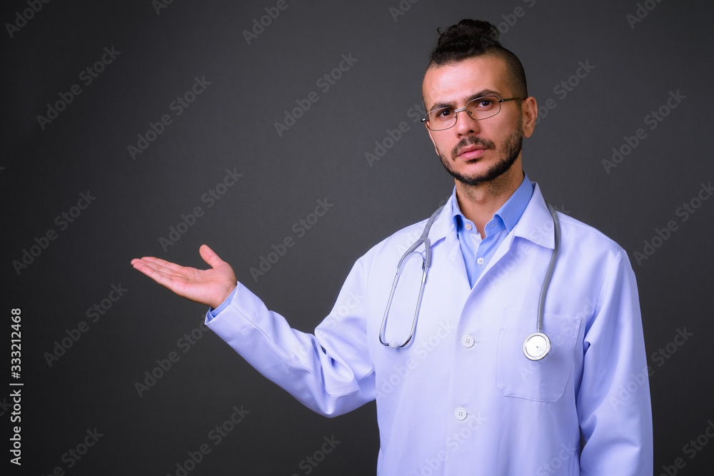 Portrait of handsome bearded Turkish man doctor showing something Portrait of handsome bearded Turkish man doctor showing something