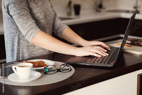 Young concentrated woman enjoying work on laptop. Positive female student doing homework, watching online webinar, listening audio course, writing emails, distantly working with wifi 