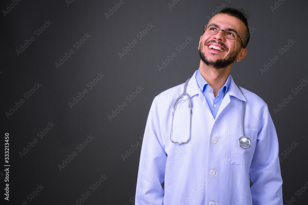 Portrait of happy bearded Turkish man doctor thinking Portrait of happy bearded Turkish man doctor thinking