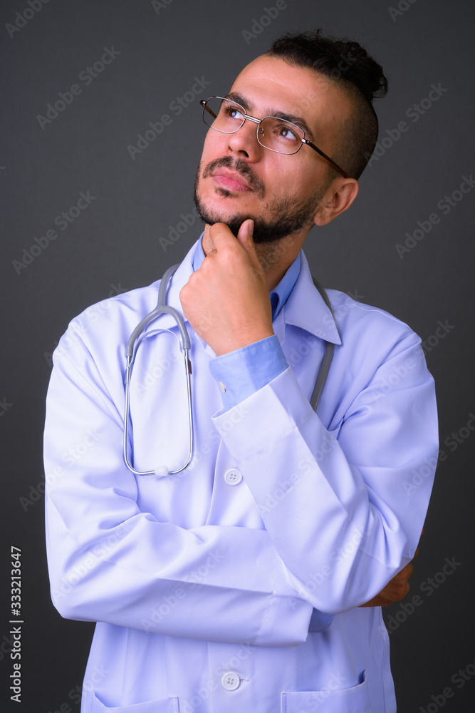 Portrait of handsome bearded Turkish man doctor thinking Portrait of handsome bearded Turkish man doctor thinking