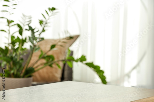 Spring time and wooden desk in home interior with blurred window. 
