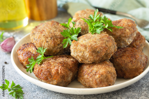 Photos Homemade juicy delicious meat cutlets in plate close-up, meatballs from minced meat on a gray stone table