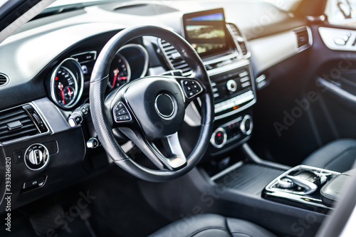 Interior view of car, Luxury car steering wheel and clean dashboard with display or monitor screen. © Milan