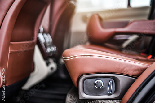 Brown luxury leather car seats with lateral support in premium class car. Control ar adjustments detail. © Milan