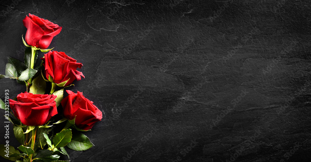 Red rose bouquet on dark banner. Roses on valentine day copy space for text. Black flowers background.