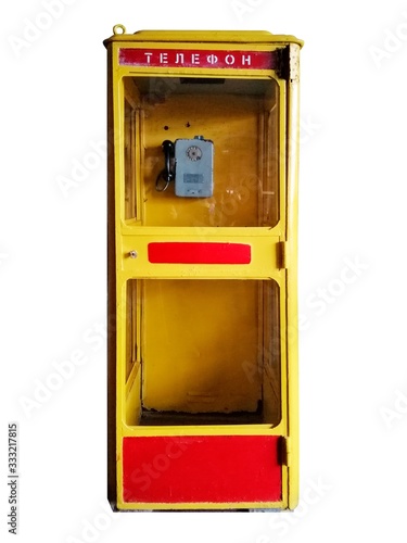 Old vintage yellow Soviet telephone box isolated on white.