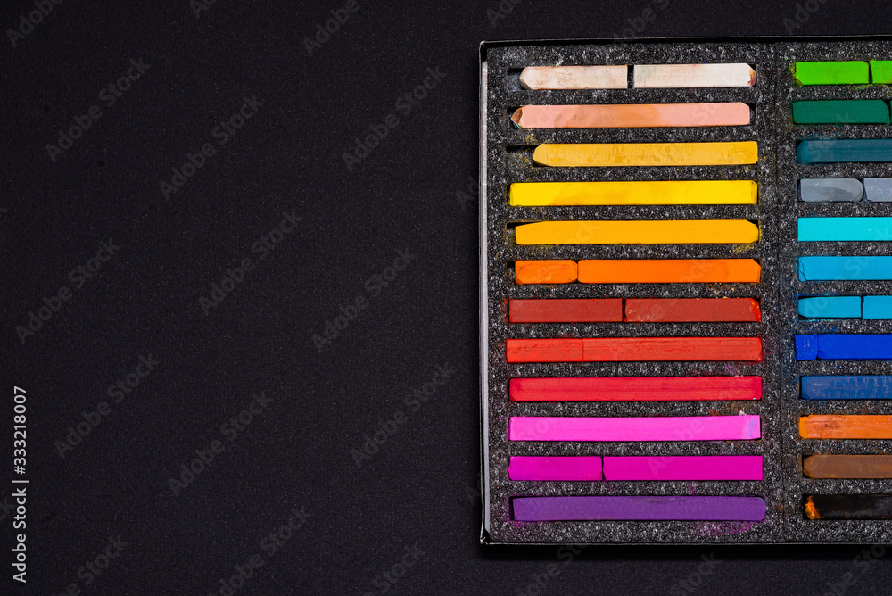 pastel crayons for drawing in a black box on a black background pastel crayons for drawing in a black box on a black background