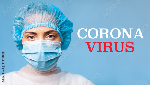 young woman doctor in a face mask and a medical cap, closeup portrait. high resolution widescreen image. CORONAVIRUS white Red inscription plate on a blue background. COVID-19