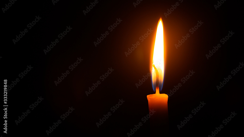 Close up single candle light and flame on black background Close up single candle light and flame on black background