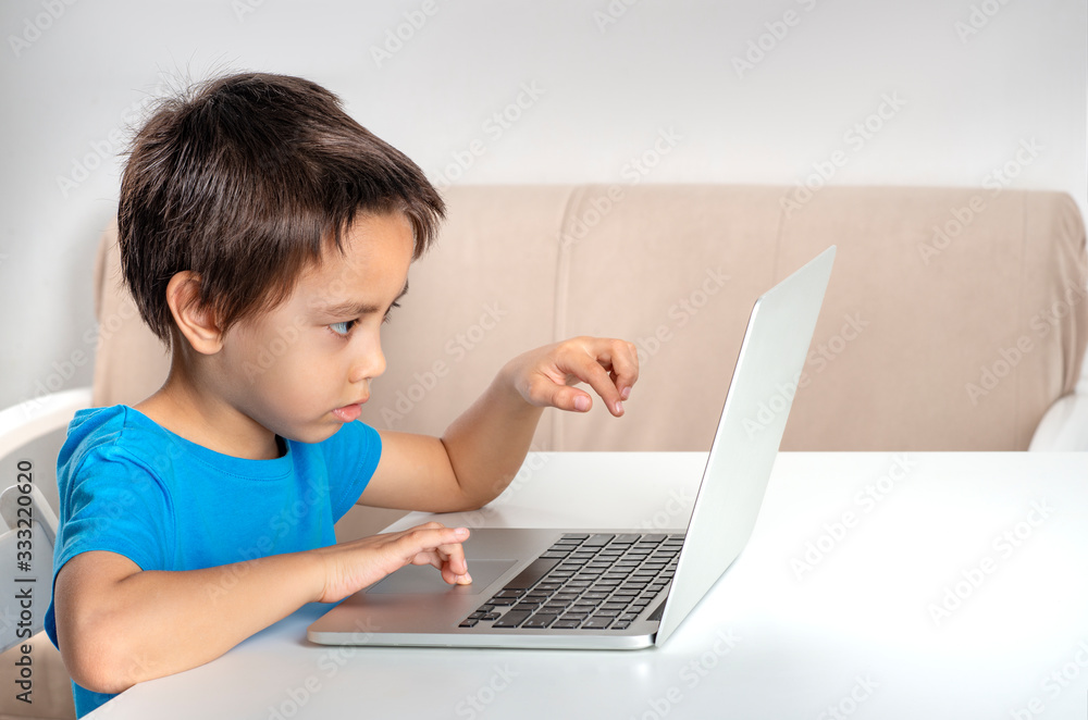 Little boy browses the internet on a laptop. Modern lifestyle. Little boy browses the internet on a laptop. Modern lifestyle.