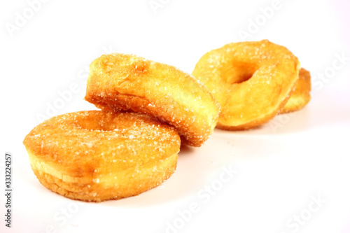 Brown donuts isolated on a white background, focus on the front, blurred back. © Mc_Shutter