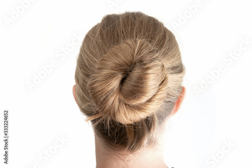 Simple bun hairstyle modeled by young white woman seen from behind close up shot isolated on white photo