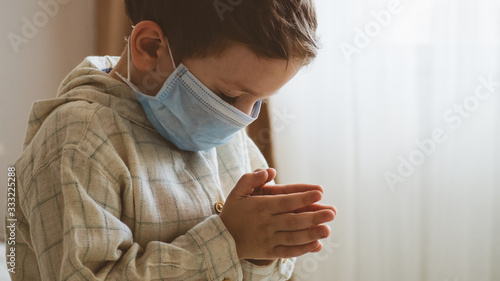 Coronavirus covid-19. Child praying to God requesting that the coronavirus covid 19 not spread beyond control.  photo