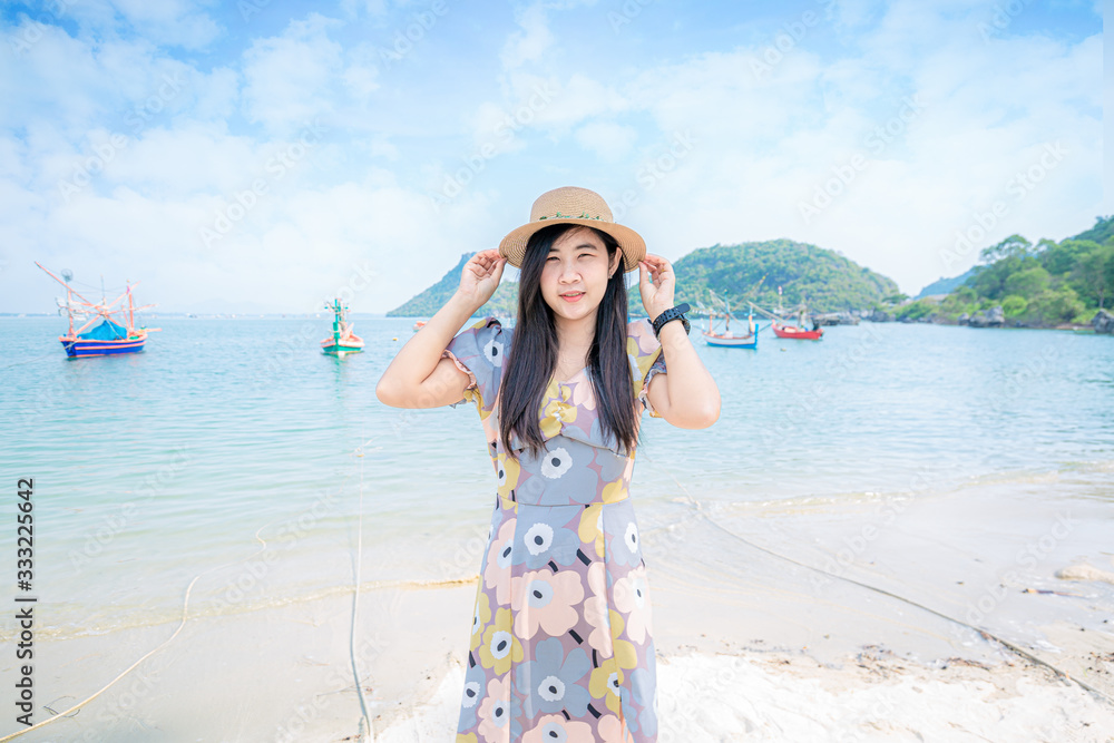 The beach woman is happy with closed eyes, enjoying the fresh air in Zen health. Asian girls wearing sun hats, enjoying summer travel on holidays.