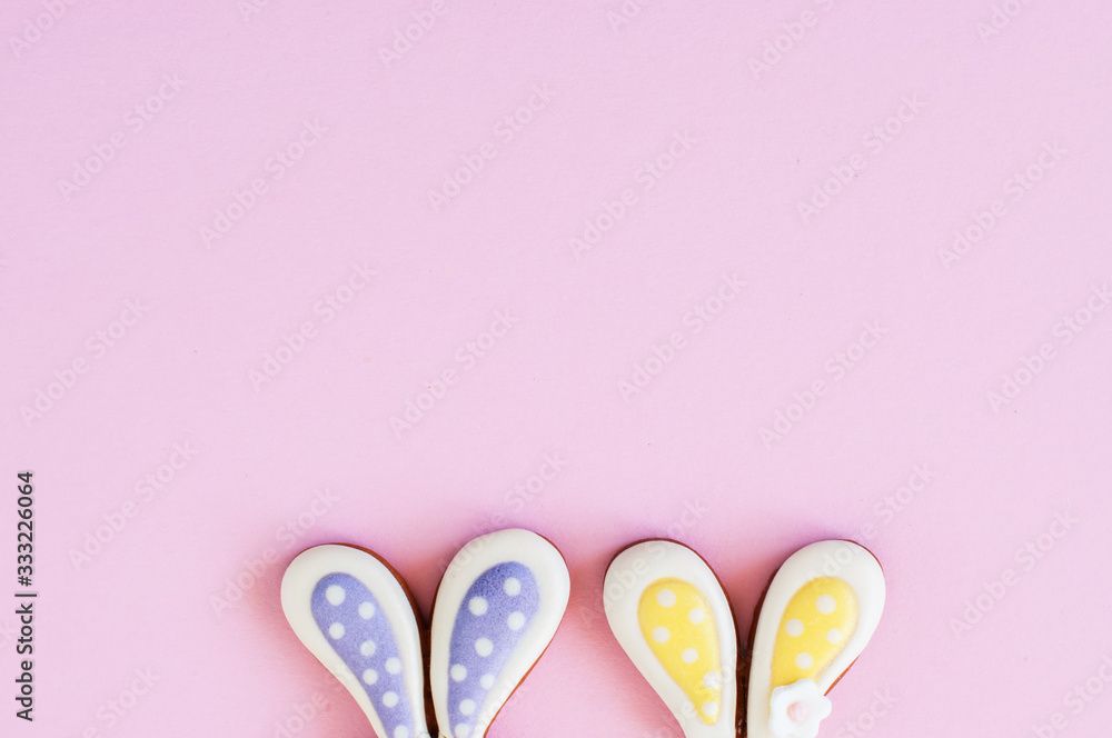 Easter background concept. Bunny ears cookies on a pink background.