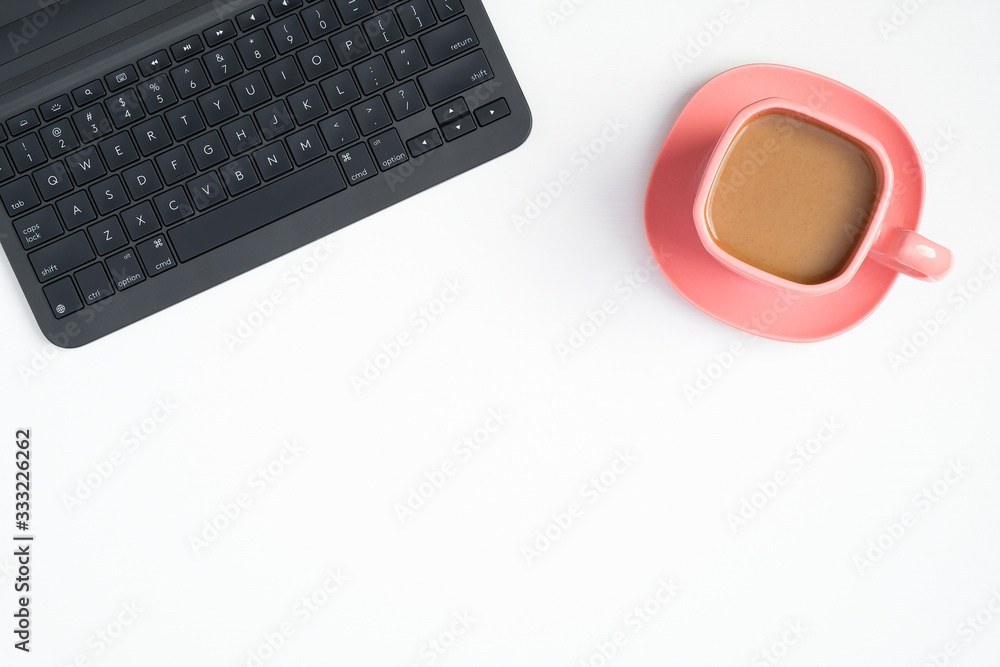 Laptop computer keyboard and pink coffee cup on white background. Elegant feminine workspace concept Top view, flat lay Laptop computer keyboard and pink coffee cup on white background. Elegant feminine workspace concept Top view, flat lay