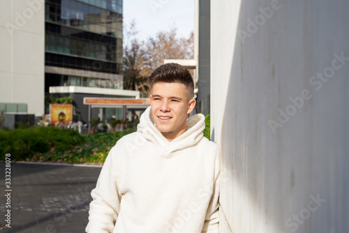 Free Download Portrait of young male with hands on pocket leaning on wall outside - GFXLoad