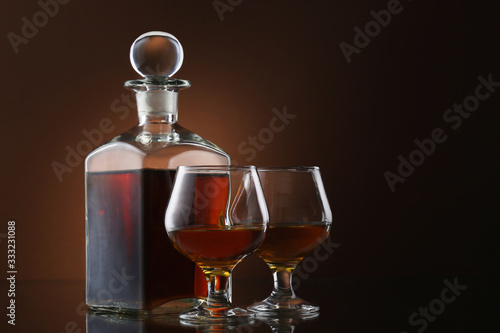 Bottle of whiskey and glass on brown background