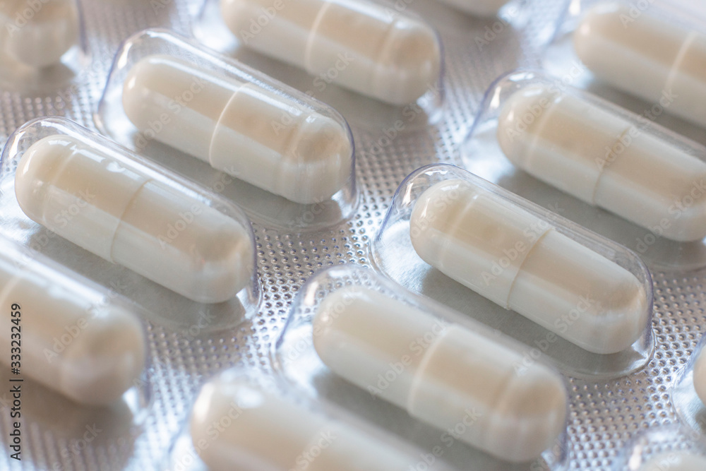 Pack of pills closeup. Diagonal row of oval long shape remedy. Background or texture about Medicine, Health, Vitamins which support human body, hepl to immune viruses and infections. Horizontal Pack of pills closeup. Diagonal row of oval long shape remedy. Background or texture about Medicine, Health, Vitamins which support human body, hepl to immune viruses and infections. Horizontal