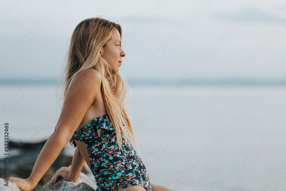 Young woman enjoying sunset on the beach