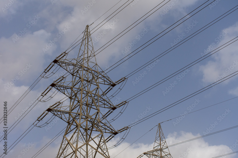 High voltage powerlines on blue sky and cloudy background in the middle east.