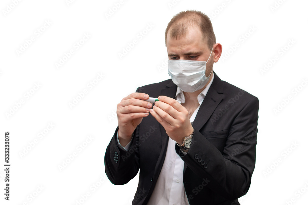 Young tired businessman in medical mask with a thermometer on a white isolated background Young tired businessman in medical mask with a thermometer on a white isolated background