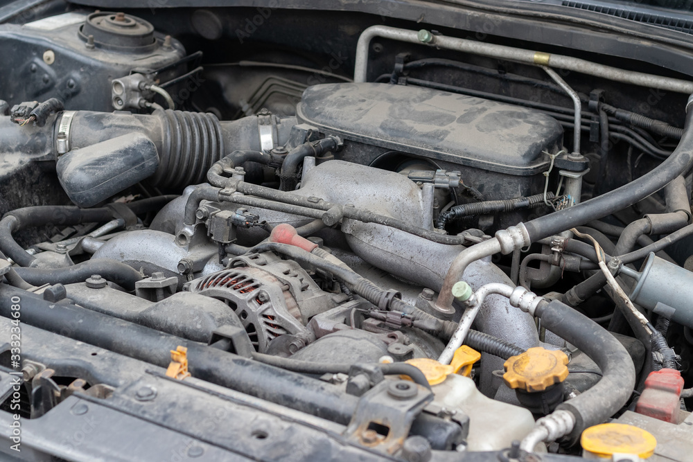 Dusty details of a flat-four (boxer) car engine compartment under the open hood. Selective focus Dusty details of a flat-four (boxer) car engine compartment under the open hood. Selective focus