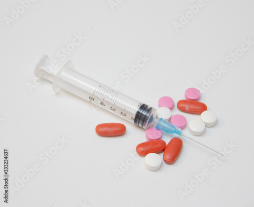 syringe with tablets of various colors and sizes