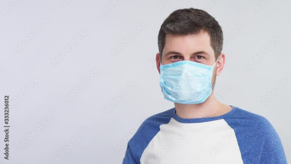 bearded man in blue shirt showing how to wear protection mask for face with OK gesture on grey bearded man in blue shirt showing how to wear protection mask for face with OK gesture on grey