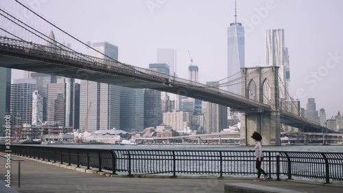 Female fitness model training outside in New York City with skyline and Brooklyn Bridge in background photo