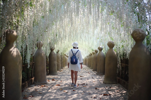 A woman walking in flower tunnel of Cherntawan International Meditation Center in Chiang Rai, Thailand