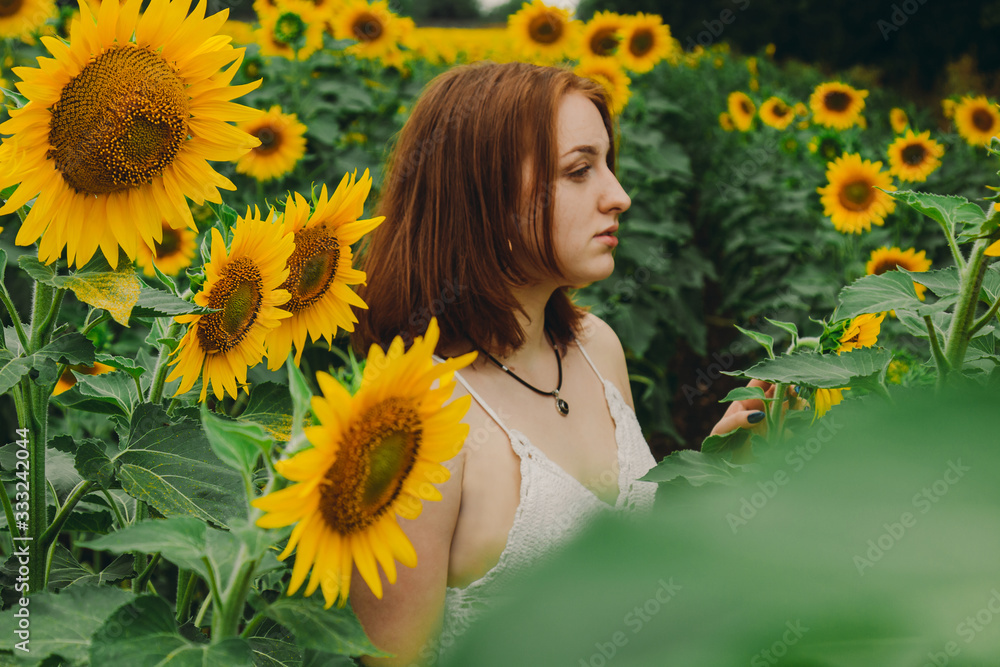 Portrait of a beautiful, cute, sexy red-haired girl in a white dress with sunflower flowers. Emotion of pleasure, freedom concept, lifestyle. Portrait of a beautiful, cute, sexy red-haired girl in a white dress with sunflower flowers. Emotion of pleasure, freedom concept, lifestyle.