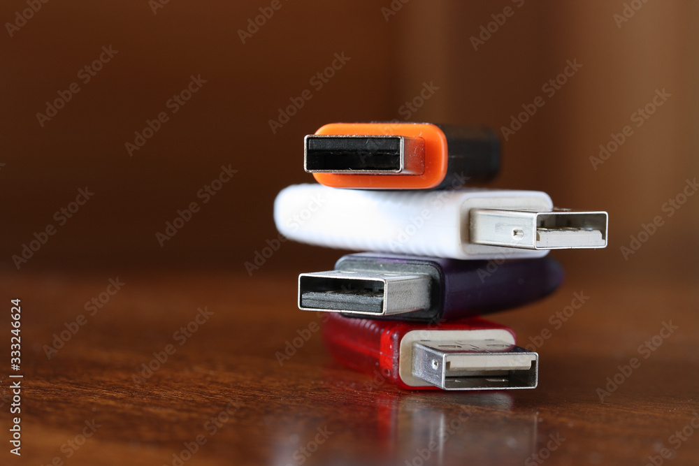 Information storage devices with usb connector with cases of various colors on a brown wooden table Information storage devices with usb connector with cases of various colors on a brown wooden table