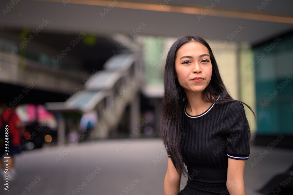 Young beautiful Asian tourist woman at the mall outdoors