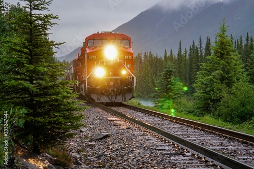 A Red Train Chugging Through the Canadian Rockies in Alberta, Canada, USA © Jeremy