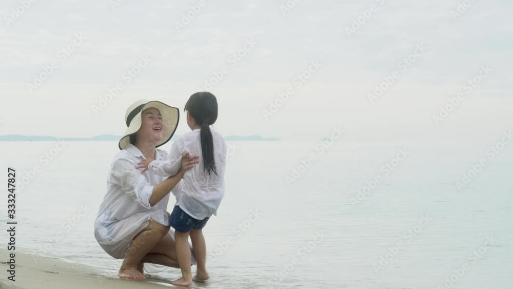 Happy asian family with mother call to daughter hug and peck on the cheek on the beach in vacation for relax, parent kiss kid with happy for leisure together, holiday and lifestyle concept. Happy asian family with mother call to daughter hug and peck on the cheek on the beach in vacation for relax, parent kiss kid with happy for leisure together, holiday and lifestyle concept.