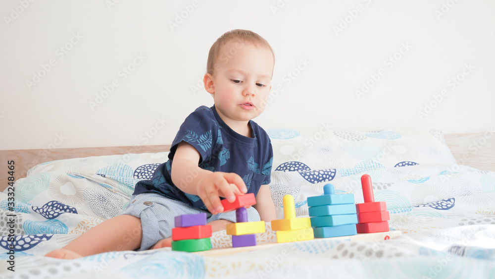 Cute small toddler doing brain exercises. Baby boy playing development montessori games. Cute small toddler doing brain exercises. Baby boy playing development montessori games.