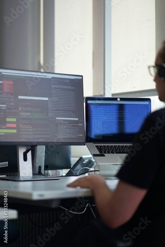 Real male web programmer coding javascript, php, symfony, react at work 