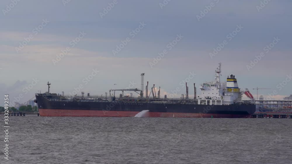 Large barge on the bay and water spills from it Large barge on the bay and water spills from it