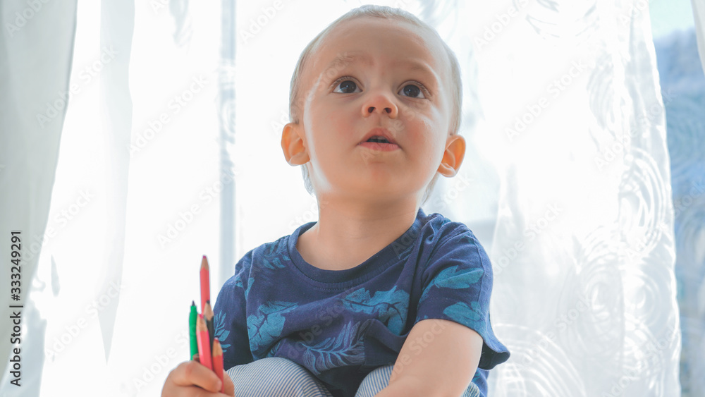 Talanted toddler discovering drawing. Baby boy learning to write with pencils. Artistic concept. Talanted toddler discovering drawing. Baby boy learning to write with pencils. Artistic concept.