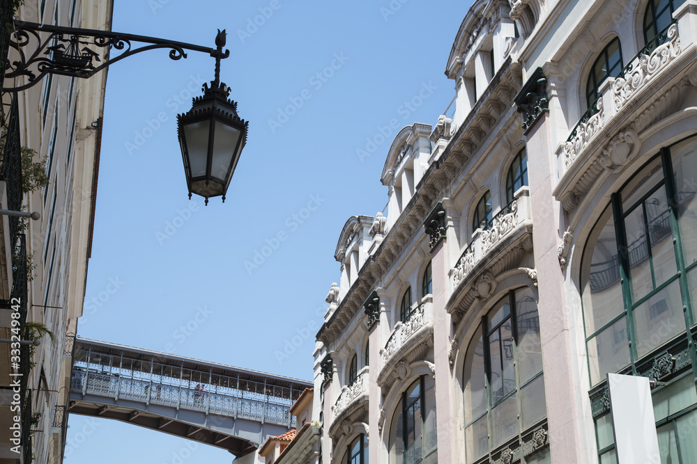 Lissabon, Portugal: Blick auf Altstadt Fassaden im Stadtviertel Baixa und Fussgängerbrücke des Aufzugs Elevador de Santa Justa