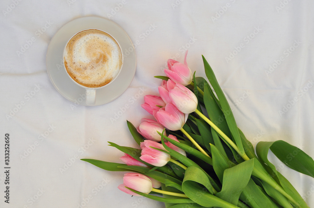 cup of coffee and bouquet of tulips on white background - obrazy, fototapety, plakaty 