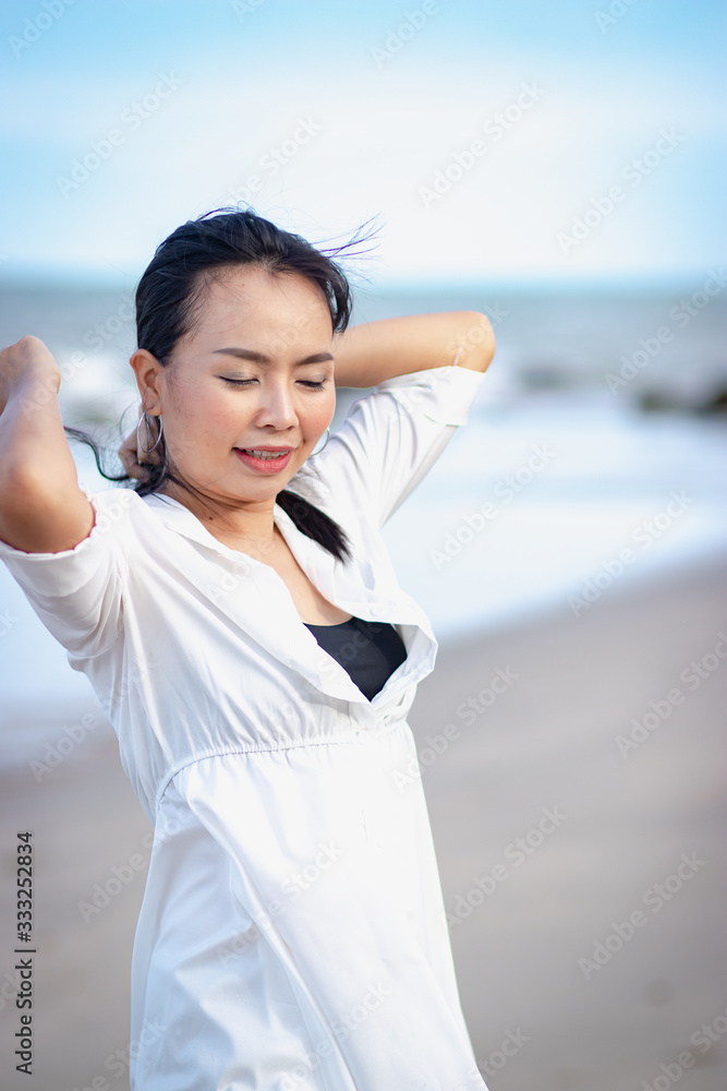 Asian woman standing and relaxing on the beach. Asian woman standing and relaxing on the beach.