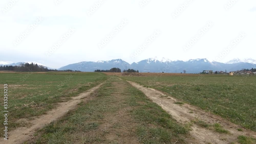 Low angle forward dolly moving over farming agriculture grass field countryside road Low angle forward dolly moving over farming agriculture grass field countryside road