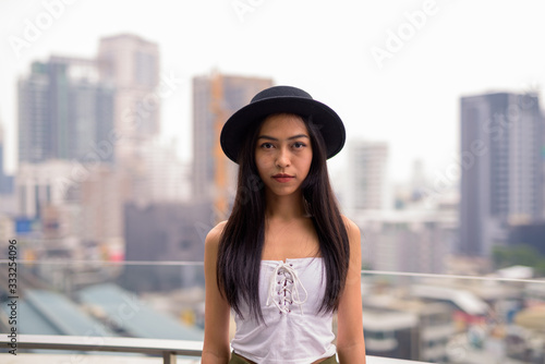 Young beautiful Asian tourist woman against view of the city © Ranta Images