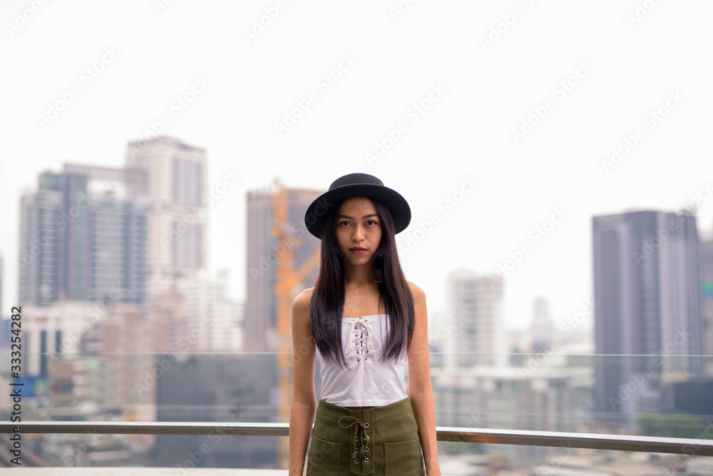 Young beautiful Asian tourist woman against view of the city Young beautiful Asian tourist woman against view of the city